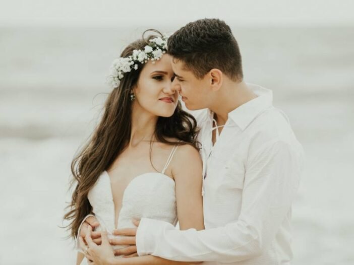 Recém casados se beijam em frente ao mar